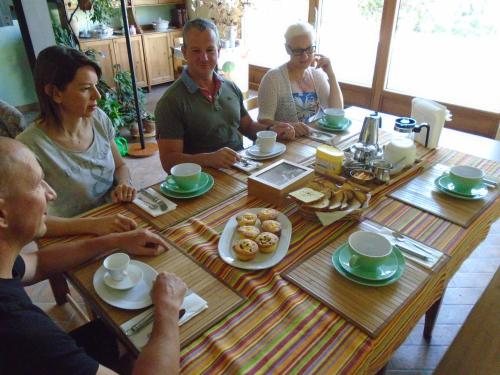 een groep mensen die rond een houten tafel zitten bij Agriturismo Loghino Sabbioni in Suzzara