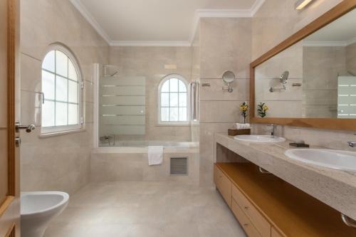 łazienka z 2 umywalkami, wanną i toaletą w obiekcie Villa Amarela w Alvor