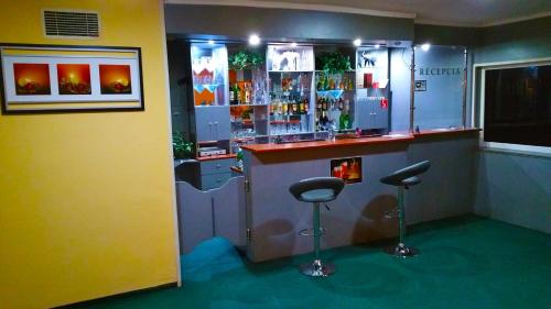 un bar con dos taburetes en una habitación en Hotel Puk, en Topoľčany