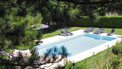 - une piscine avec des chaises longues dans la cour dans l'établissement Le Jardin de Celina, à Valensole