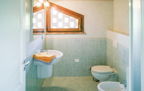 uma casa de banho com um lavatório, um WC e uma janela. em Villa Marina - with private panoramic pool em Orciatico