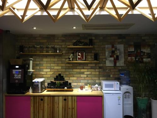 kuchnia z blatem z kuchenką mikrofalową i lodówką w obiekcie OHHO Hotel w mieście Gimhae