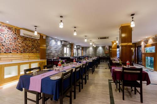 a row of tables in a restaurant with blue table cloth at Hotel Southern Residency- near to SIPCOT in Kelambākkam