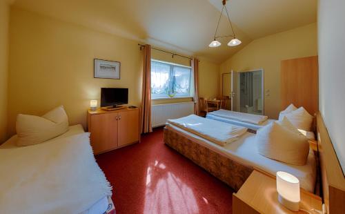 En eller flere senger på et rom på Hotel-Pension Lender