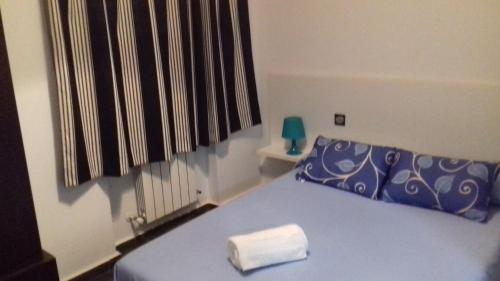a bedroom with a blue bed with a towel on it at Apartamentos Turísticos Los Ángeles in Alcázar de San Juan