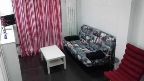 a living room with a couch and a table at Apartamentos Turísticos Los Ángeles in Alcázar de San Juan