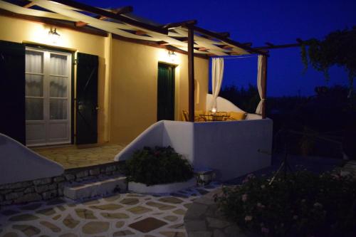 a house with a bathtub in the yard at night at Tzane Studios & Apartments - Steps away from Golden Beach in Chrissi Akti