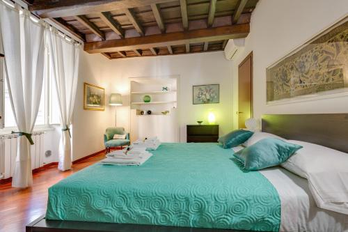 a bedroom with a large bed with a green blanket at Rome as you feel - Panisperna Apartment in Rome