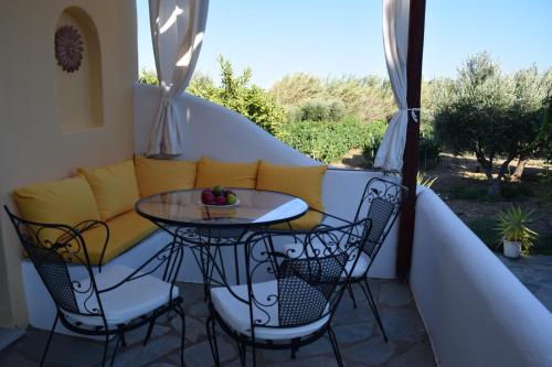 a balcony with a table and chairs and a couch at Tzane Studios & Apartments - Steps away from Golden Beach in Chrissi Akti