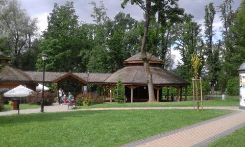 a pavilion in a park with people walking around it at Apartament Parkowy Rabka in Rabka-Zdrój