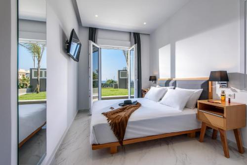 a bedroom with a bed and a large window at Elysian Suites in Hersonissos