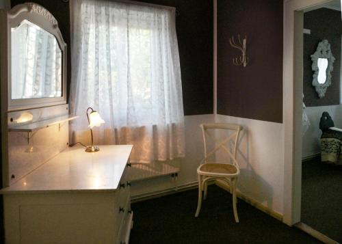 グロースシェーナウにあるGoldberghaus Mauveのデスク、椅子、窓が備わる客室です。