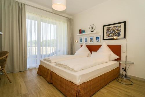 a bedroom with a large bed with white pillows at Ostseedomizil La Mer in Börgerende-Rethwisch