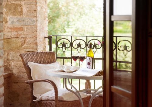 アッシジにあるレジデンツァ デポカ サン クリスピノのバルコニーにテーブルとワイン2杯
