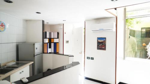 ナポリにあるBellini Casa Vacanzeのキッチン(冷蔵庫付)、窓が備わります。
