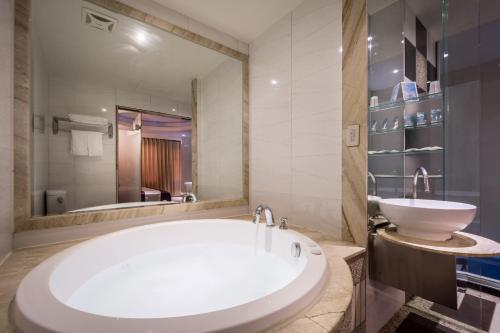 uma casa de banho com uma banheira grande e um lavatório em Ching Ching Motel em Sanxia