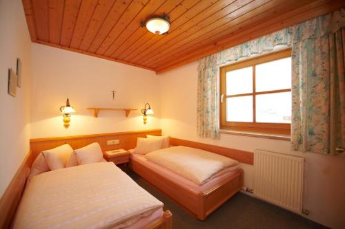 pokój z dwoma łóżkami i oknem w obiekcie Pension Hedegghof w mieście Grossarl