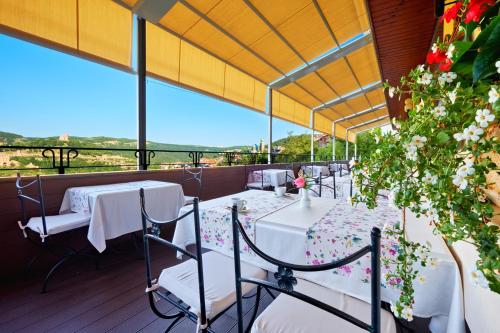 a restaurant with tables and chairs on a balcony at Yantra Grand Hotel in Veliko Tŭrnovo