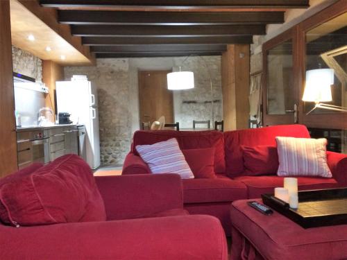 sala de estar con sofá rojo y cocina en Niu, en Saldet