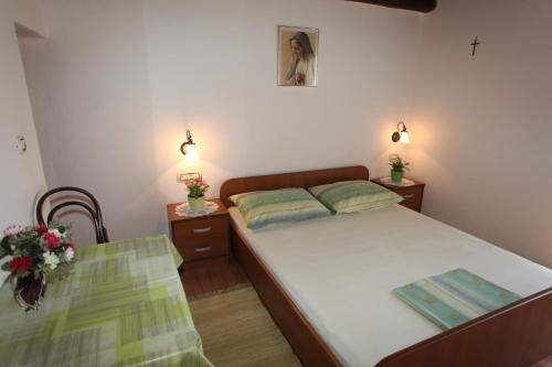 um pequeno quarto com uma cama e uma mesa em Accommodation Lily em Vrana