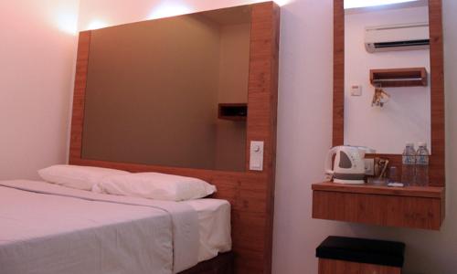 a bedroom with a large mirror above a bed at Dream Hotel in Klang