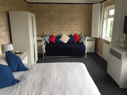 a bedroom with a bed with blue and red pillows at The Moorland Hotel in Wotter