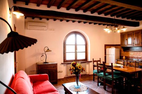 salon z czerwoną kanapą i stołem w obiekcie Agriturismo Podere dei kiwi w mieście Chiesina Uzzanese