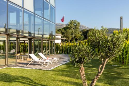 a glass house with a lawn and two lounge chairs at The Fortyfive Business Hotel & Spa in Manisa
