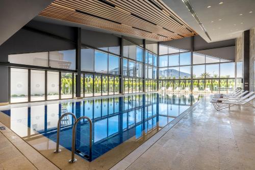 a swimming pool in a building with windows at The Fortyfive Business Hotel & Spa in Manisa