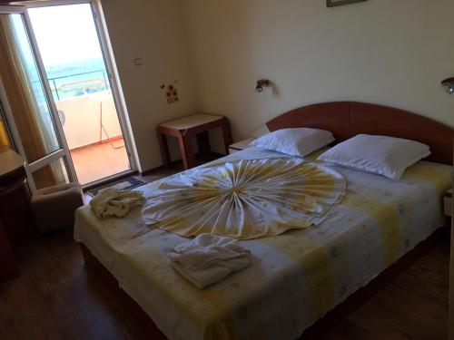 a bedroom with a large bed with an umbrella on it at Guest House Hetodon in Sozopol