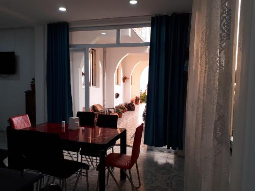 una sala da pranzo con tavolo, sedie e tende blu di Rezo's House a Kvariati