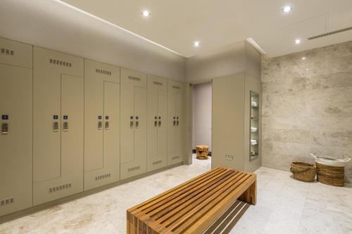 a row of lockers in a locker room with a bench at The Fortyfive Business Hotel & Spa in Manisa