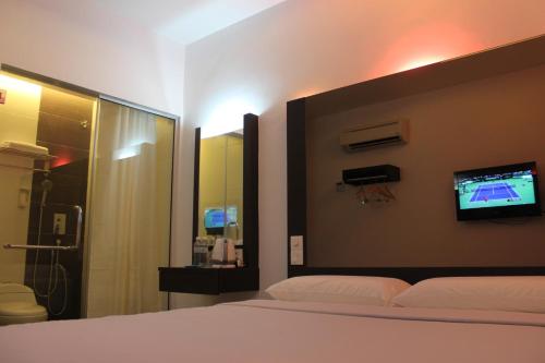 1 dormitorio con 1 cama y TV en la pared en Dream Hotel, en Klang