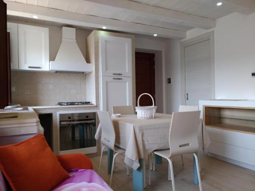 a kitchen with a table with white chairs and a table and a table at Villa Greco in Rossano