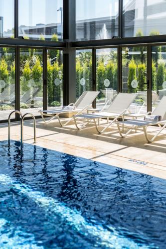 a swimming pool with lounge chairs next to a building at The Fortyfive Business Hotel & Spa in Manisa