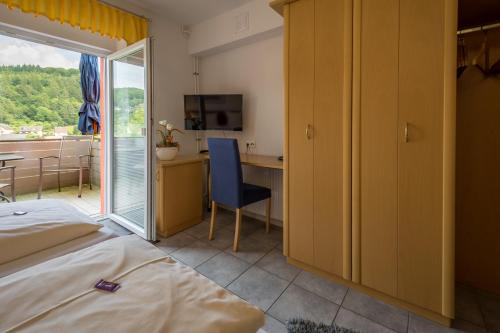 a bedroom with a bed and a desk and a table at Pension Margarethe in Biedenkopf
