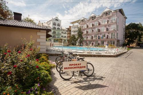 a bike parked next to a hotel with a sign on it at Tvorcheskaya Volna Resort in Koktebel