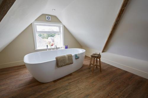 a bathroom with a white tub in a attic at Lyndhurst House in Lyndhurst