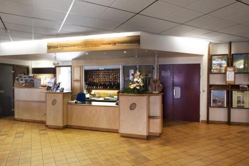 a restaurant with a counter and a bar with flowers at L'ESCANDILLE Village Vacances in Autrans