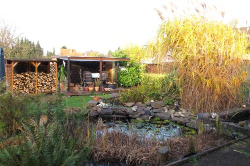 a garden with a pond and a house with a pavilion at Komfortwohnung City/Messe 25 Min in Cologne