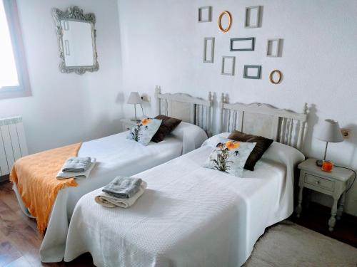 two beds in a room with white walls at Agroturismo Ondarre in Segura