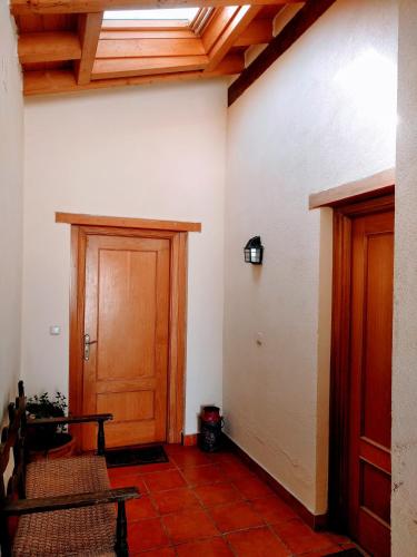 a hallway with two wooden doors and red tiles at Agroturismo Ondarre in Segura