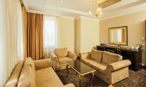 a living room with a couch and chairs and a table at Hotel Intourist Palace Batumi in Batumi