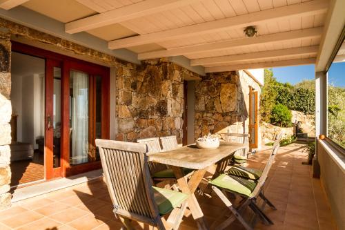 an outdoor patio with a wooden table and chairs at Molarotto in Porto Taverna