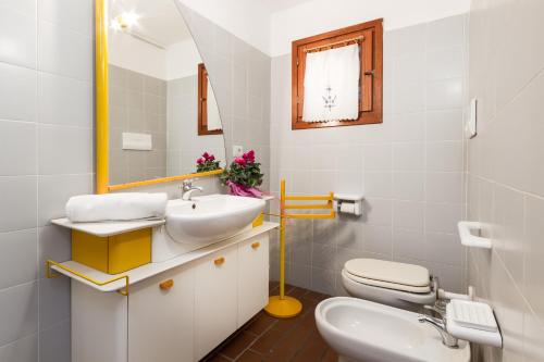 a bathroom with a sink and a toilet and a mirror at Molarotto in Porto Taverna