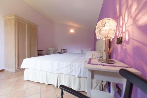 コルテ・フランカにあるB&B Il dossoのベッドルーム1室(ベッド1台、ランプ付きテーブル付)