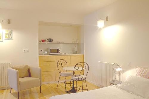 a bedroom with a bed and a table and chairs at Clos Mirabel Manor - Holiday rental in Jurançon
