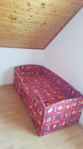 a bed in a room with a wooden ceiling at Apartman Nóra II. in Bük