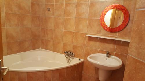 y baño con bañera, lavabo y espejo. en Apartman Nóra II., en Bük
