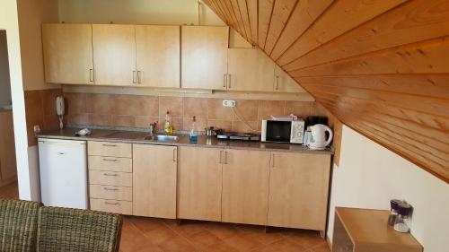 cocina con armarios de madera y encimera en Apartman Nóra II., en Bük